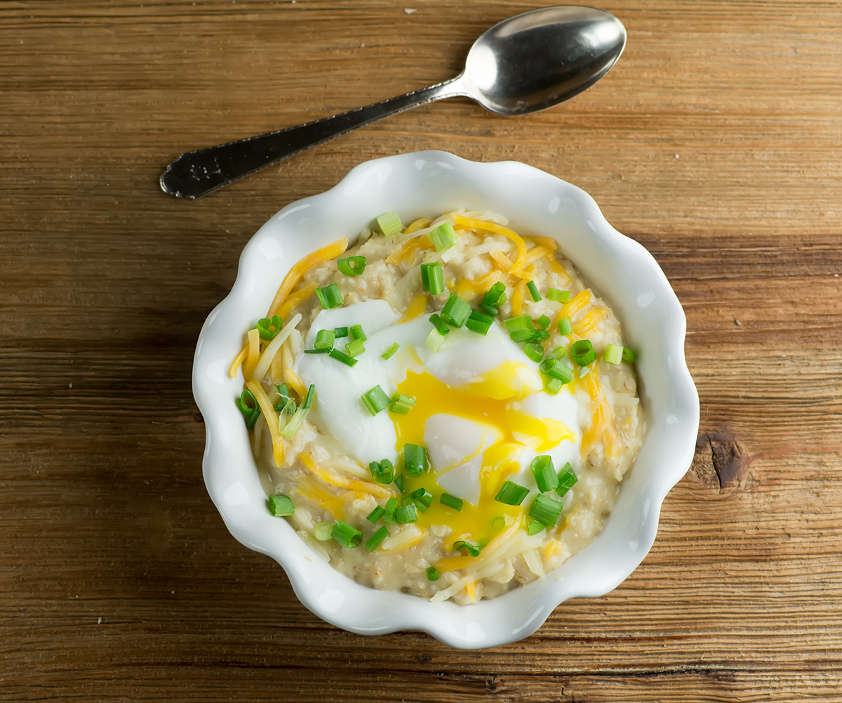 A bowl of savory oatmeal with a poached egg on top.