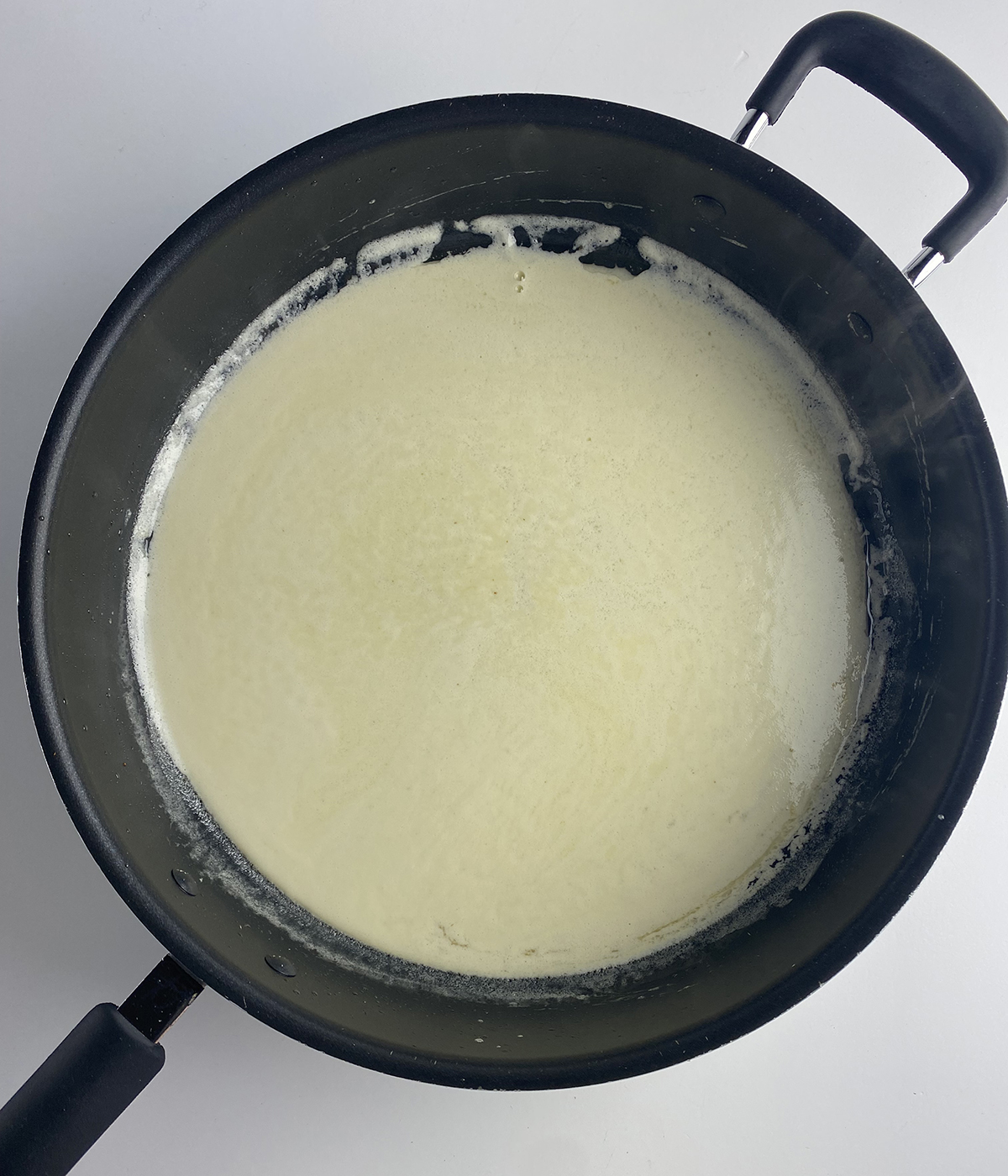Cream sauce cooking in a skillet.