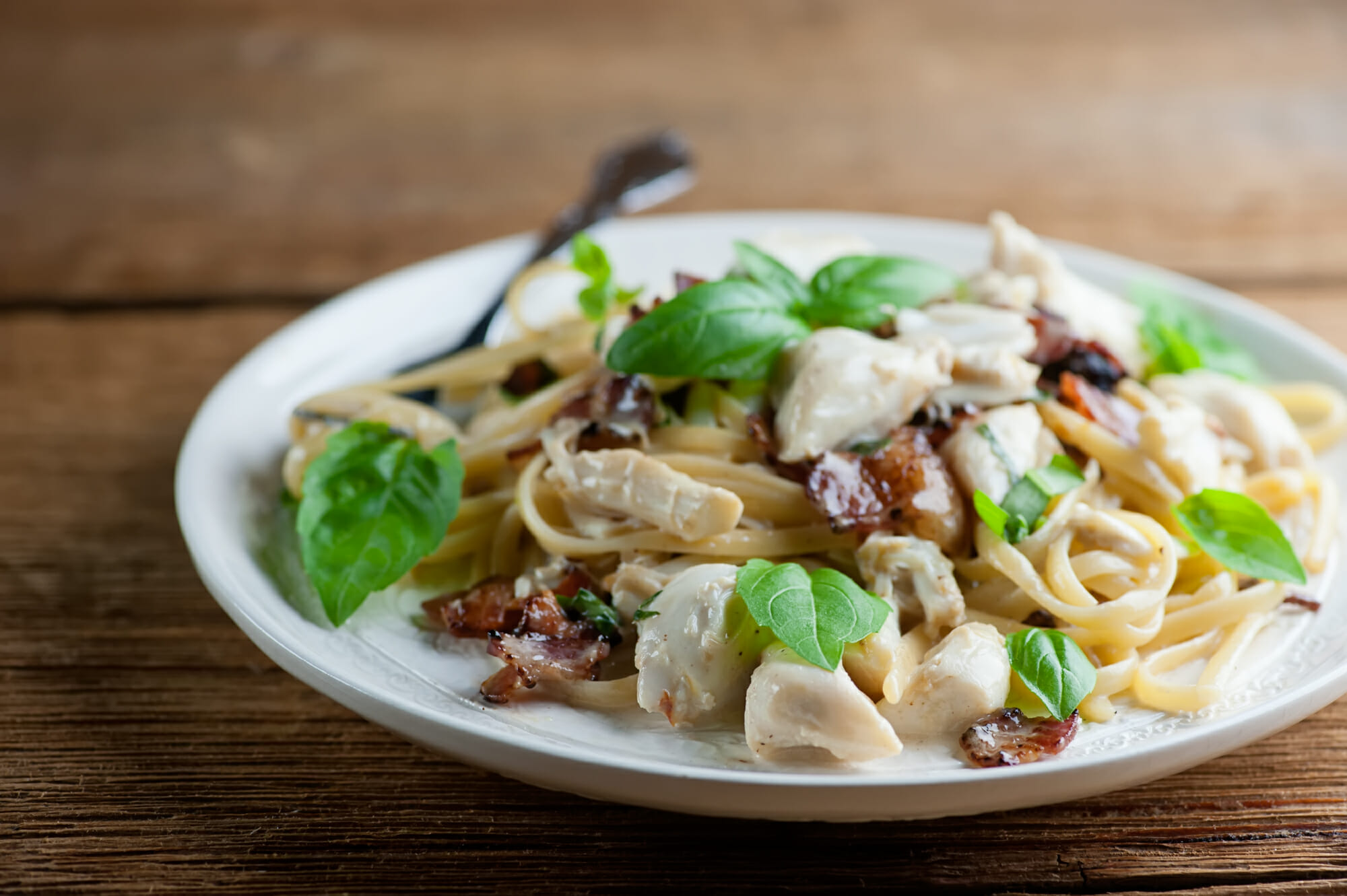 Bacon crab pasta on a plate with a fork.