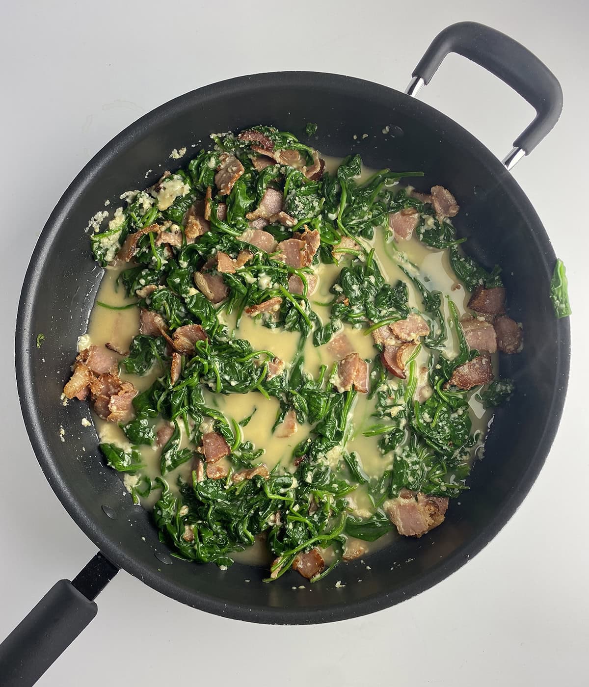 Spinach bacon sauce in a pan.