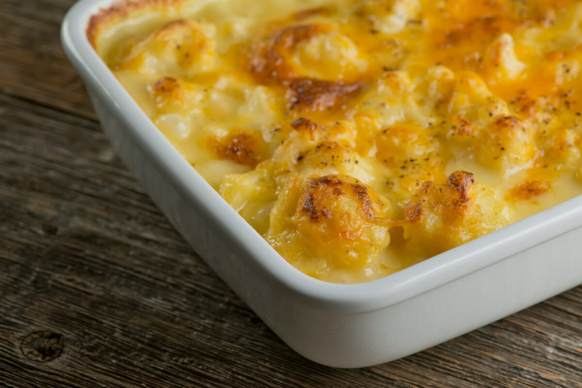 Cheesy cauliflower casserole on a wooden counter.