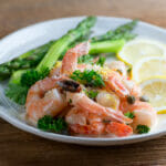 Easy creamy shrimp piccata ona plate with asparagus.