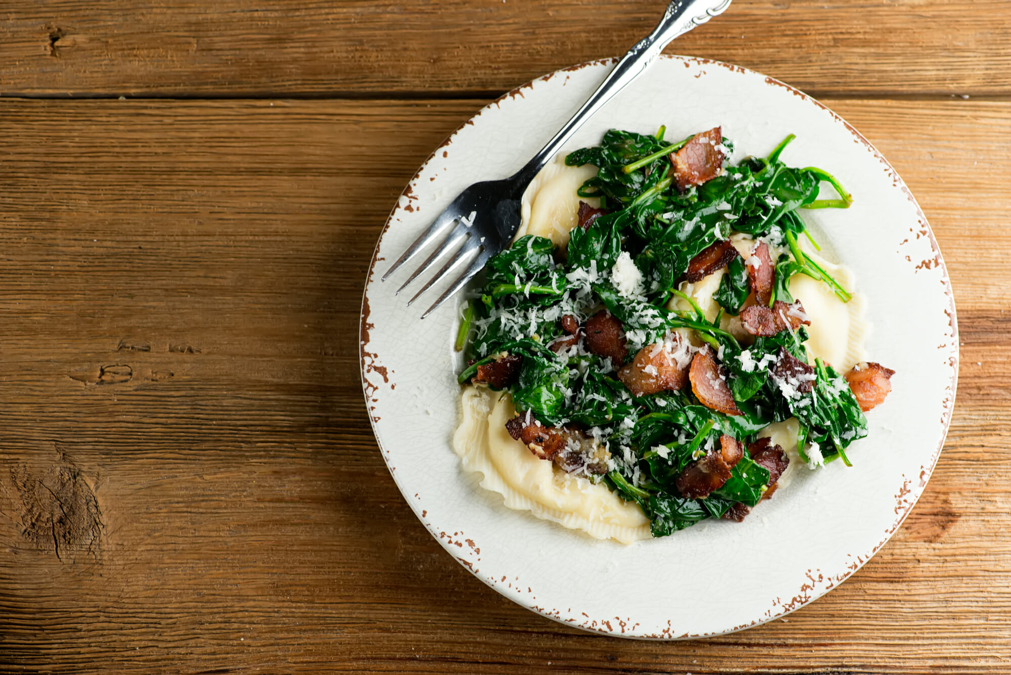 ravioli with bacon and spinach Plate of easy ravioli with baby spinach and bacon.