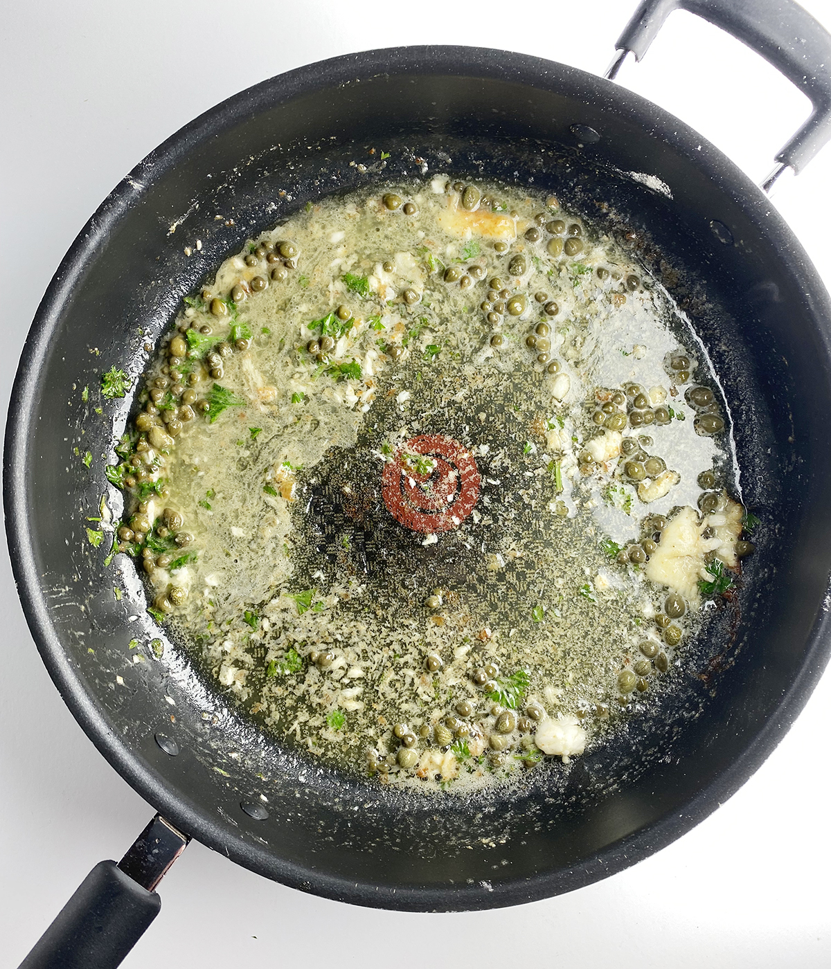 Lemon butter sauce in a skillet.