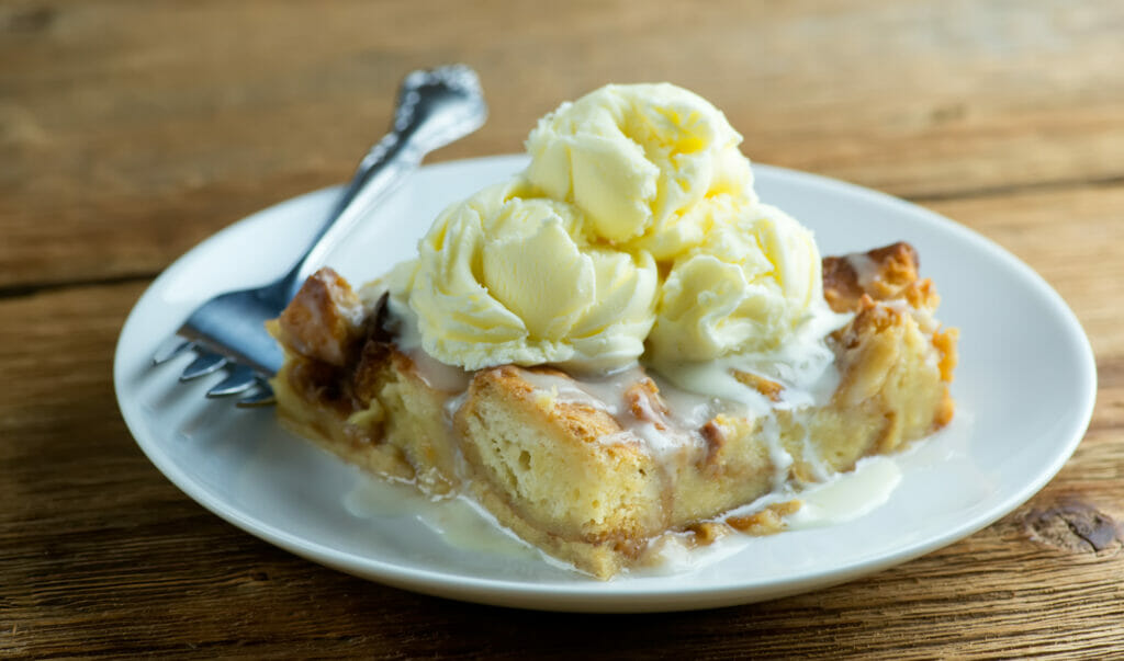 Cinnamon roll bread pudding with ice cream on top.