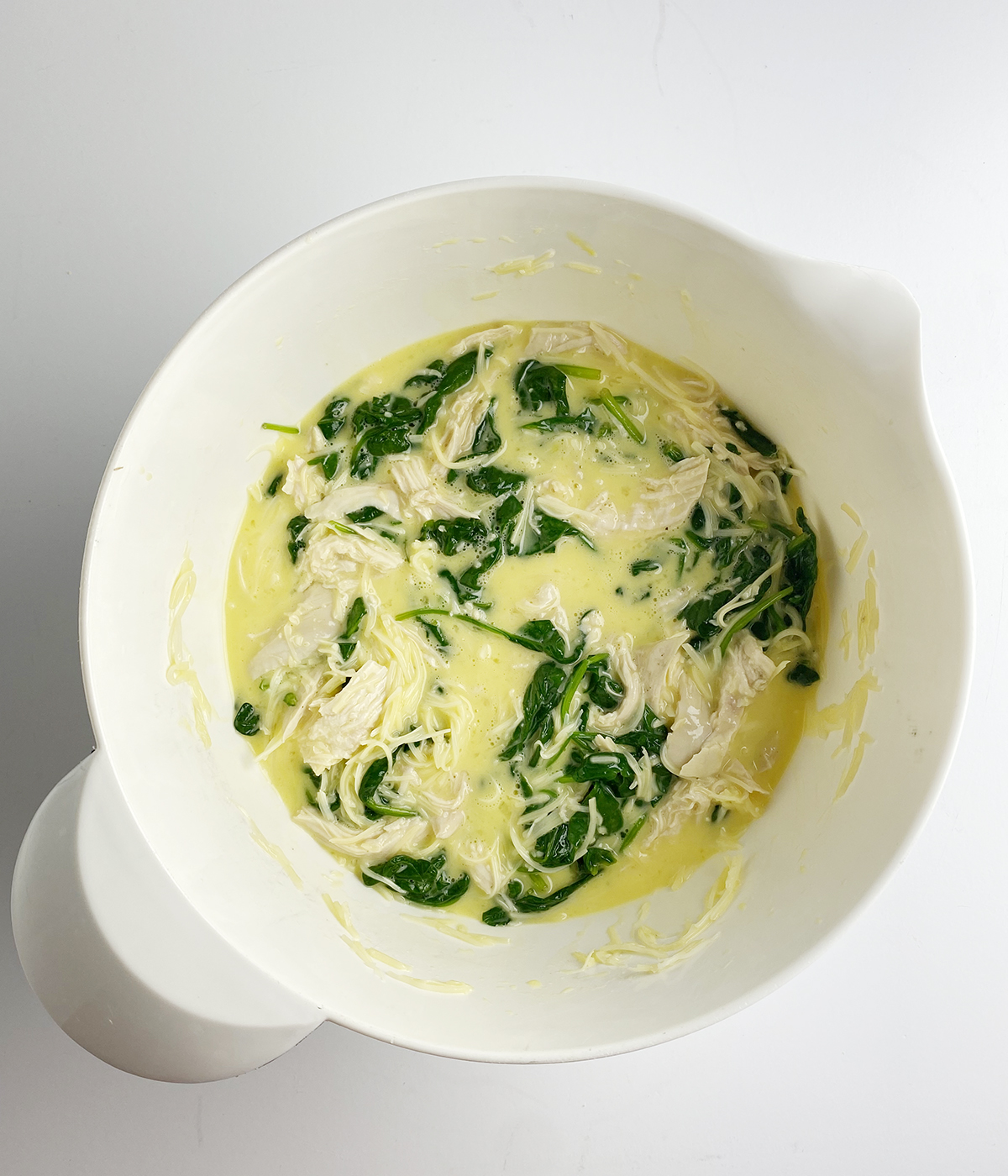 Chicken spinach frittata mixture in a mixing bowl.