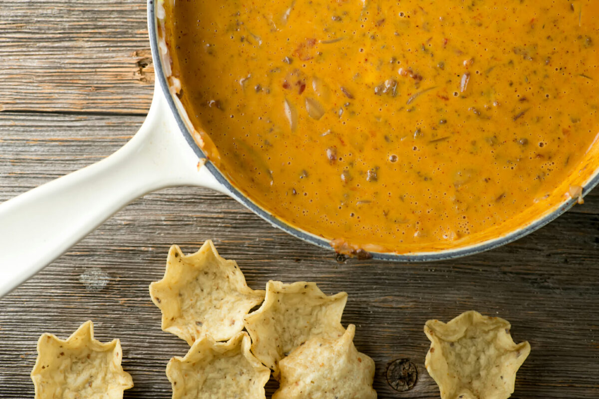Chili cheese dip in a skillet with tortilla chips.