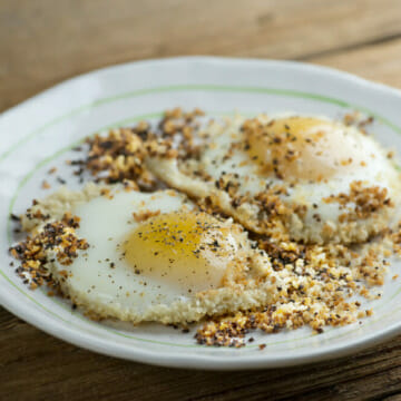 Bread crumb fried eggs on a white plate.