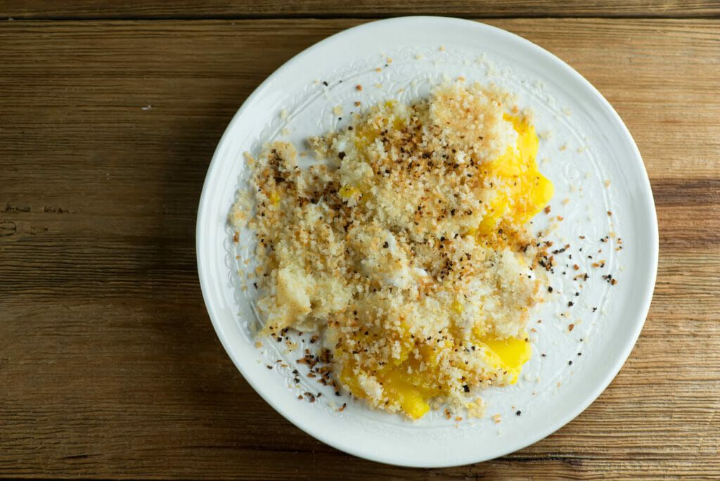 Over easy fried bread crumb eggs on a plate.