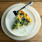 Cheesy Chicken Spinach Oven Frittata on a plate with a fork.