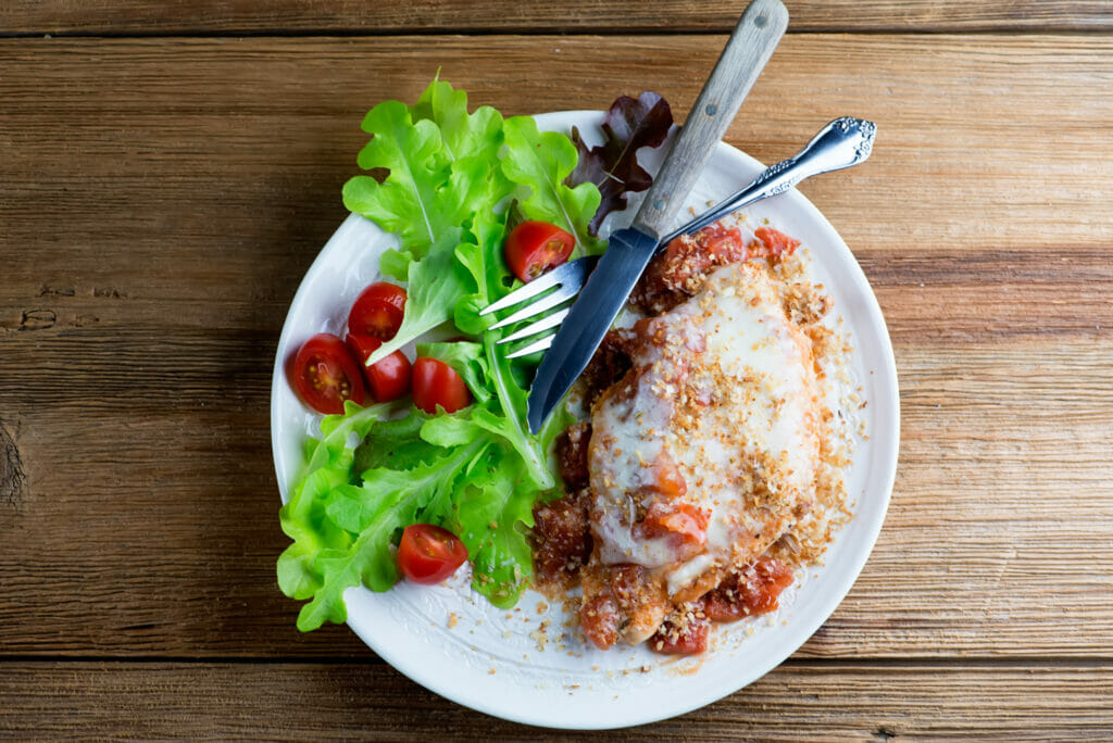 One Pan Chicken Parmesan on a plate with a side salad.