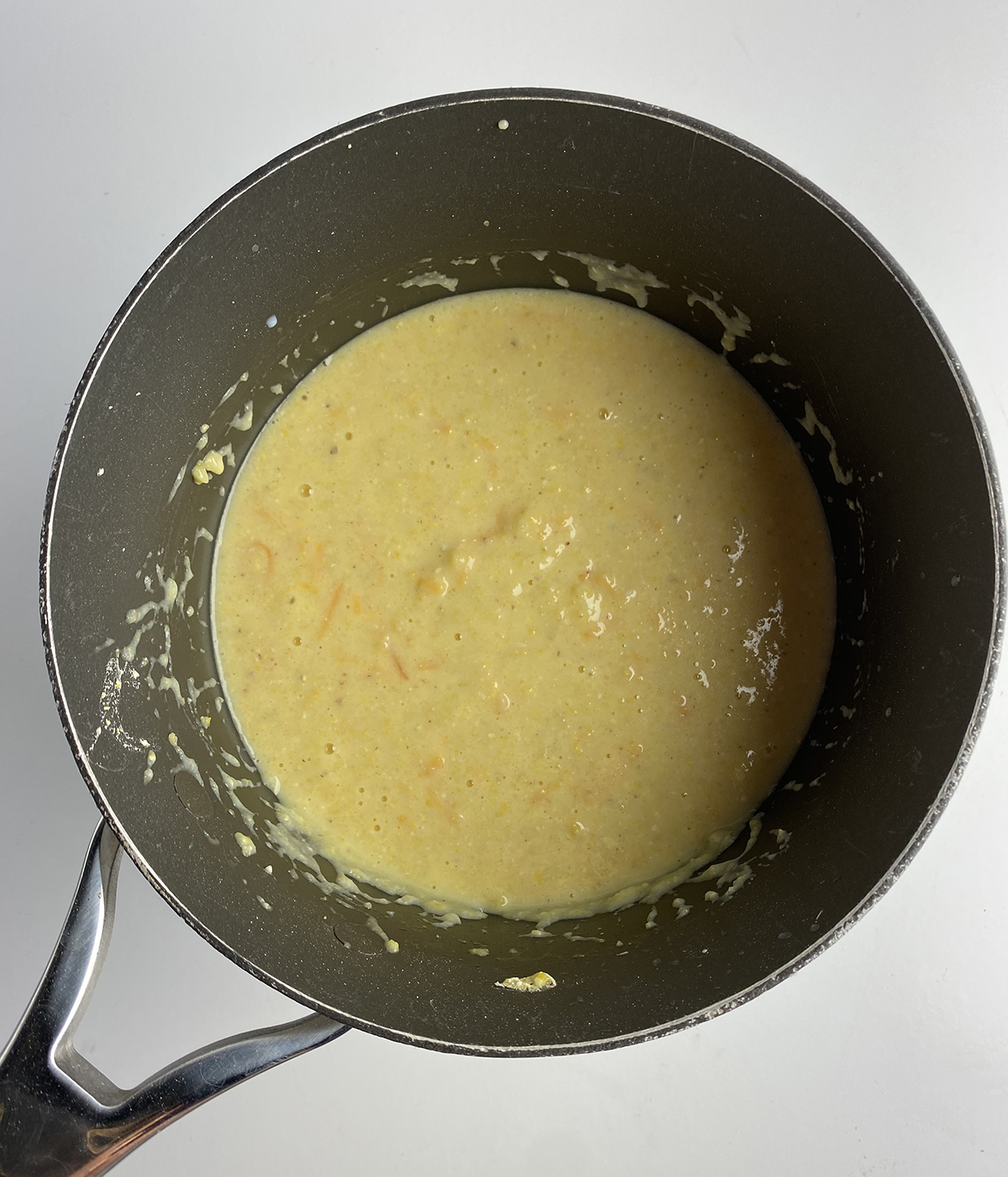 Spoonbread batter with cheese in a pan.
