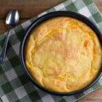 Cheesy Southern spoonbread on a dishtowel.