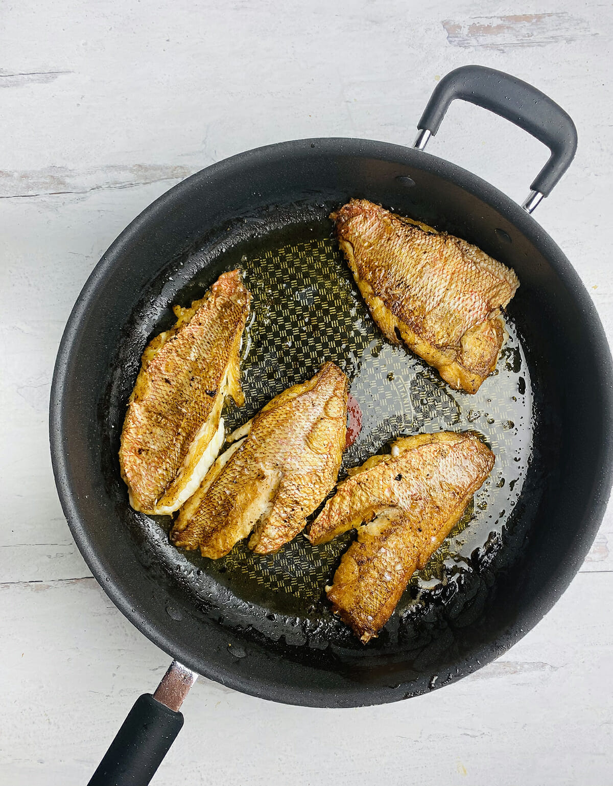 red snapper searing in pan