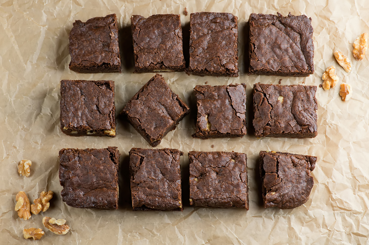 Saucepan brownies with walnuts on a piece of parchment.