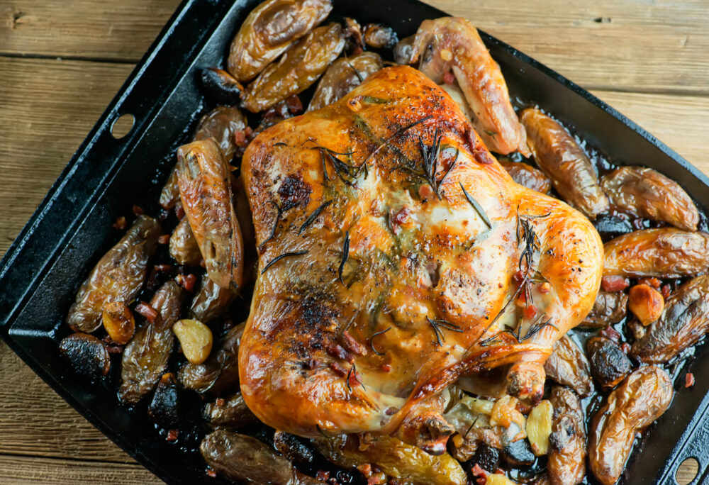 Spatchcock Chicken and Potatoes in a baking pan.