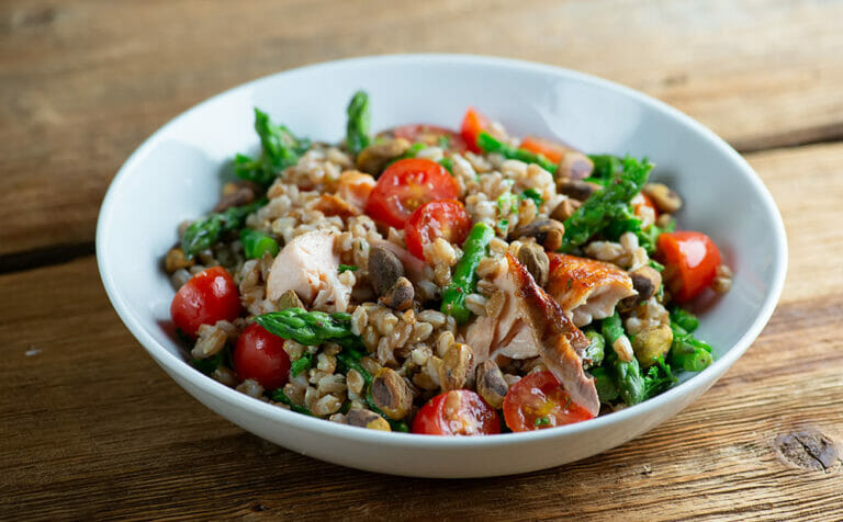 Easy roasted salmon grain bowl on a wooden counter.