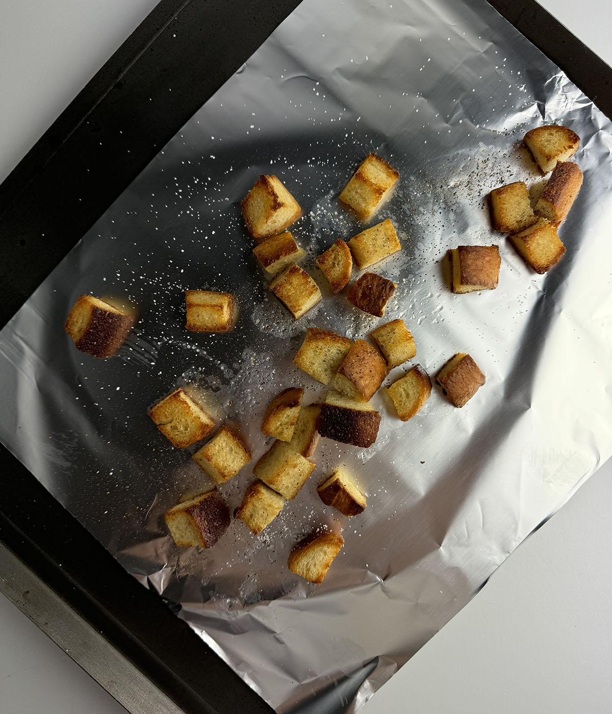 Toasted croutons on a cookie sheet.