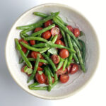 Cherry tomato green bean salad in a ceramic bowl.