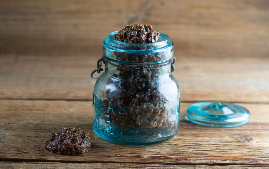 No bake chocolate haystack cookies ina blue glass jar.