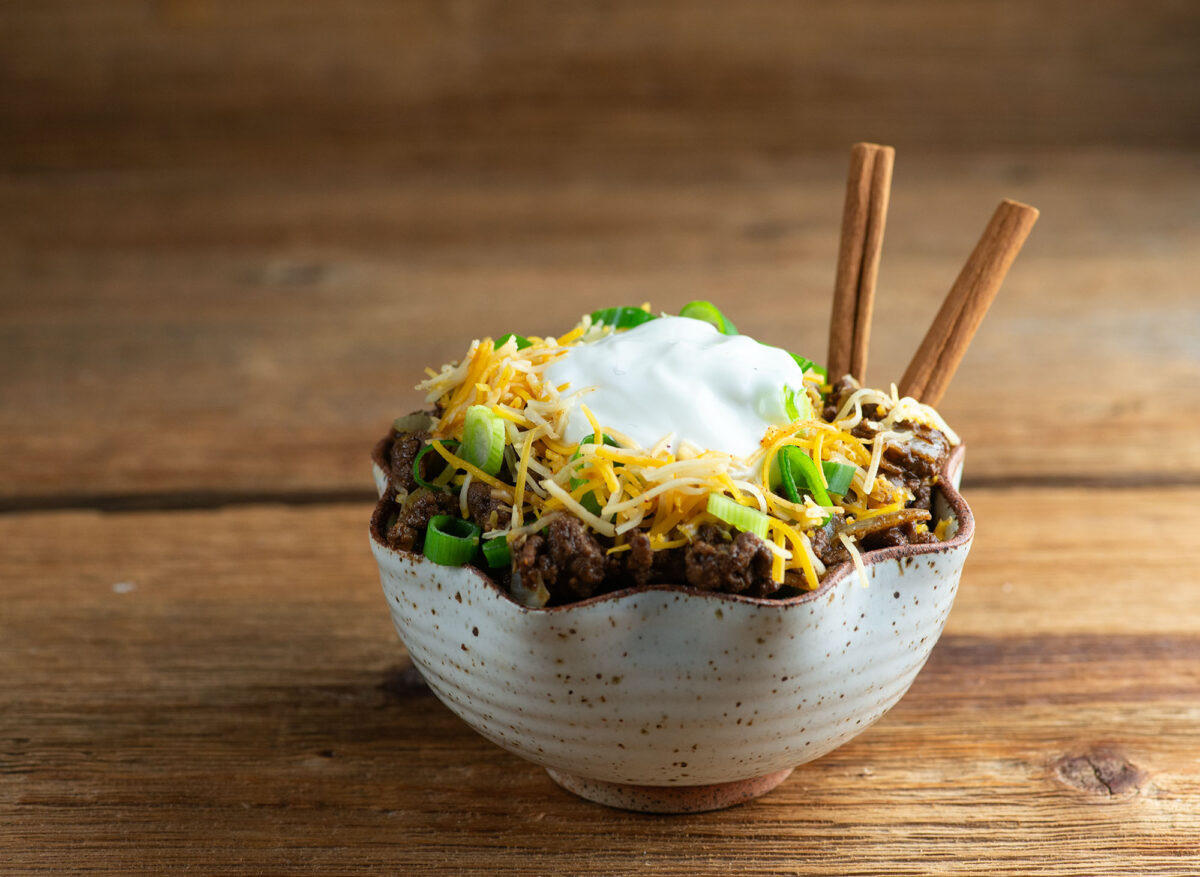 Easy Cinnamon Chili in a bowl with cinnamon sticks.
