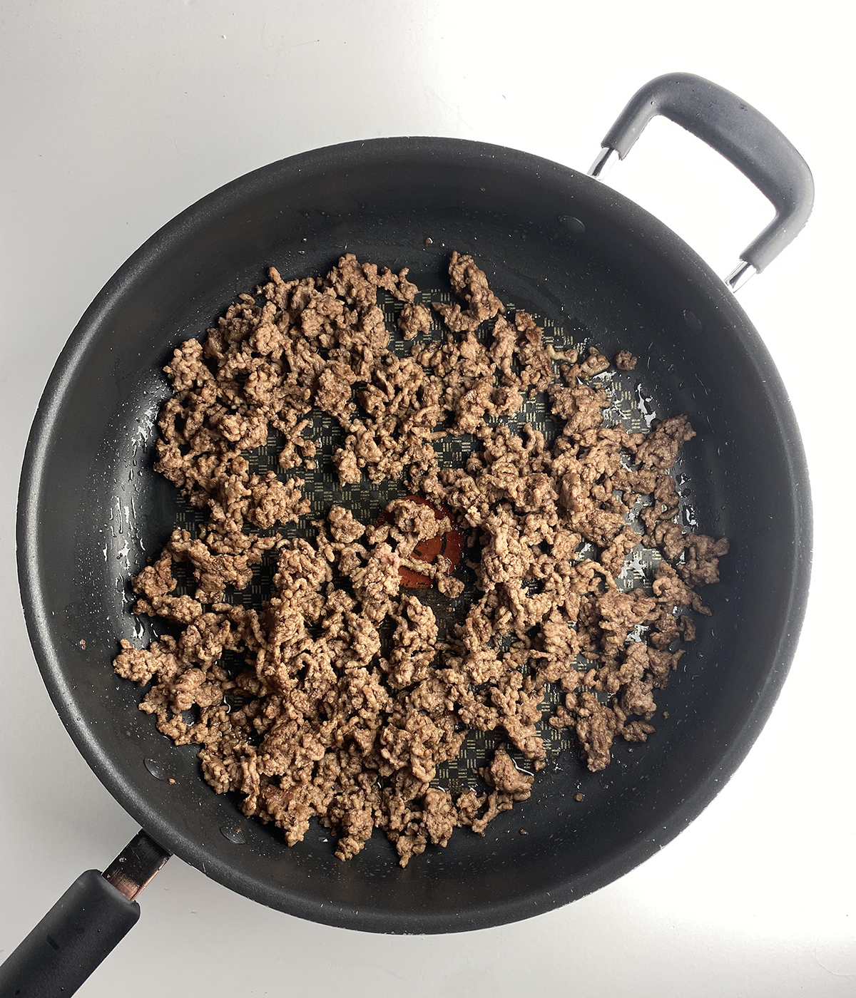 Cooked ground beef in a skillet.