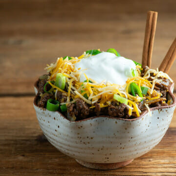 Easy Cinnamon Chili in a bowl on a wooden counter.