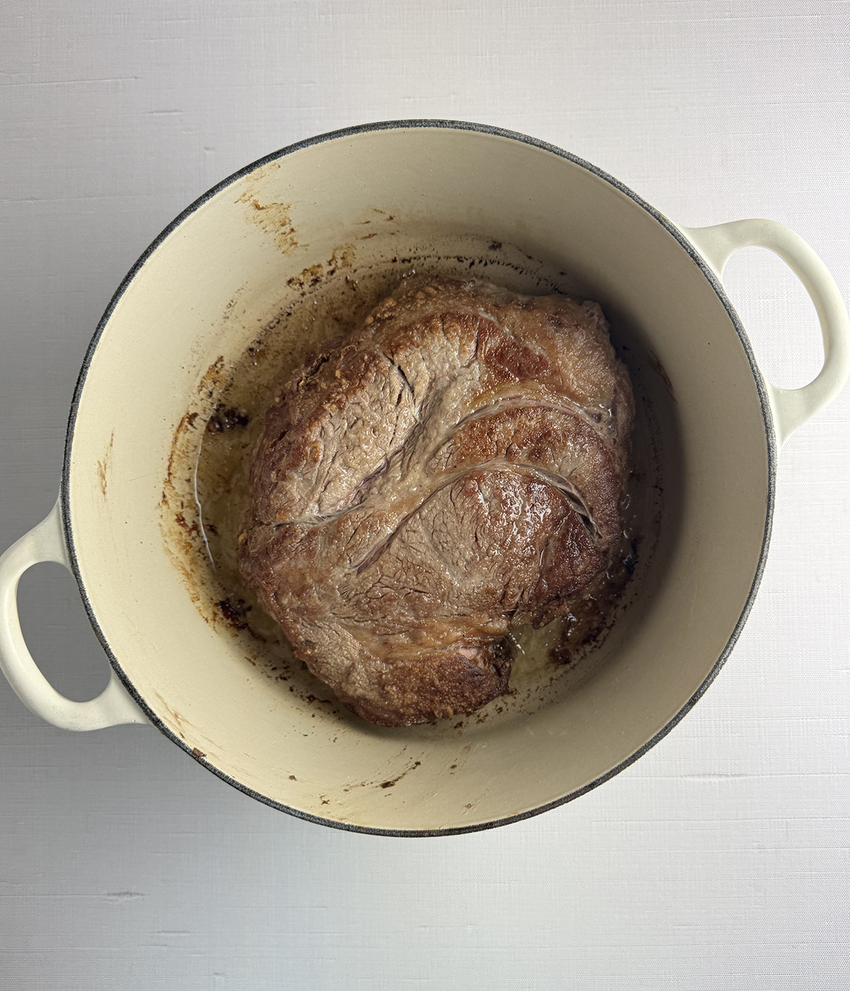 Seared pot roast in a Dutch oven.