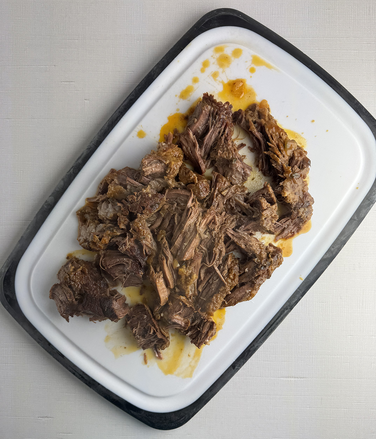 Shredded pot roast on a cutting board.