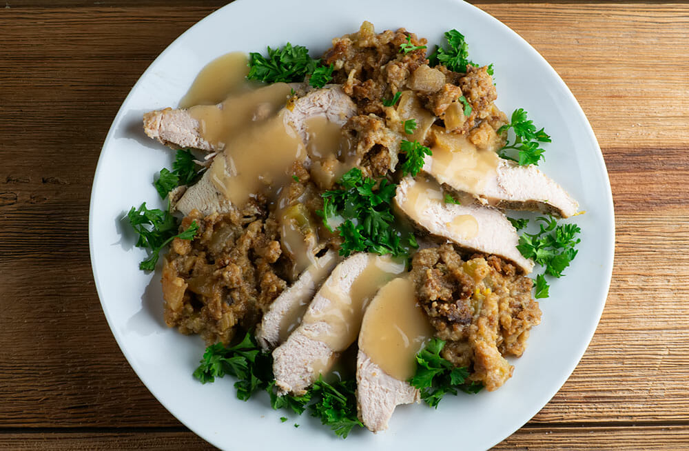 Easy slow cooker turkey with stuffing sliced and on a plate.