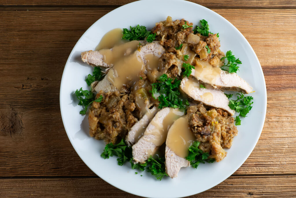 Slow cooker turkey with stuffing with gravy on a plate.