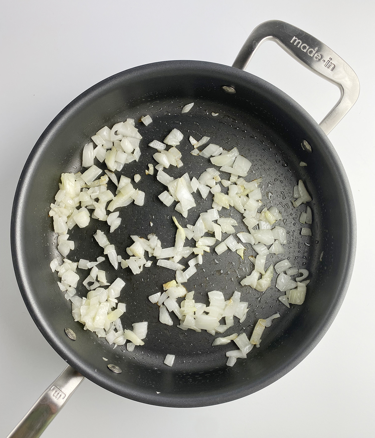 Chopped onions cooking in a skillet.