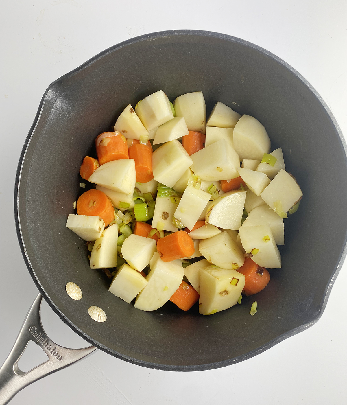 Chopped vegetables for winter vegetable soup in a pot.