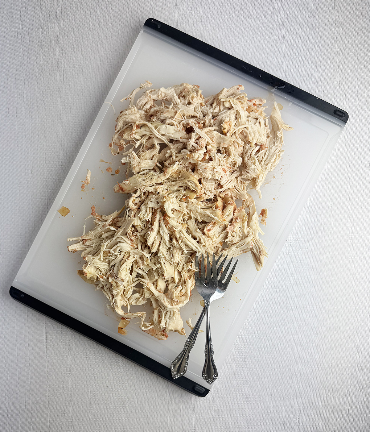 Shredded chicken on a cutting board.