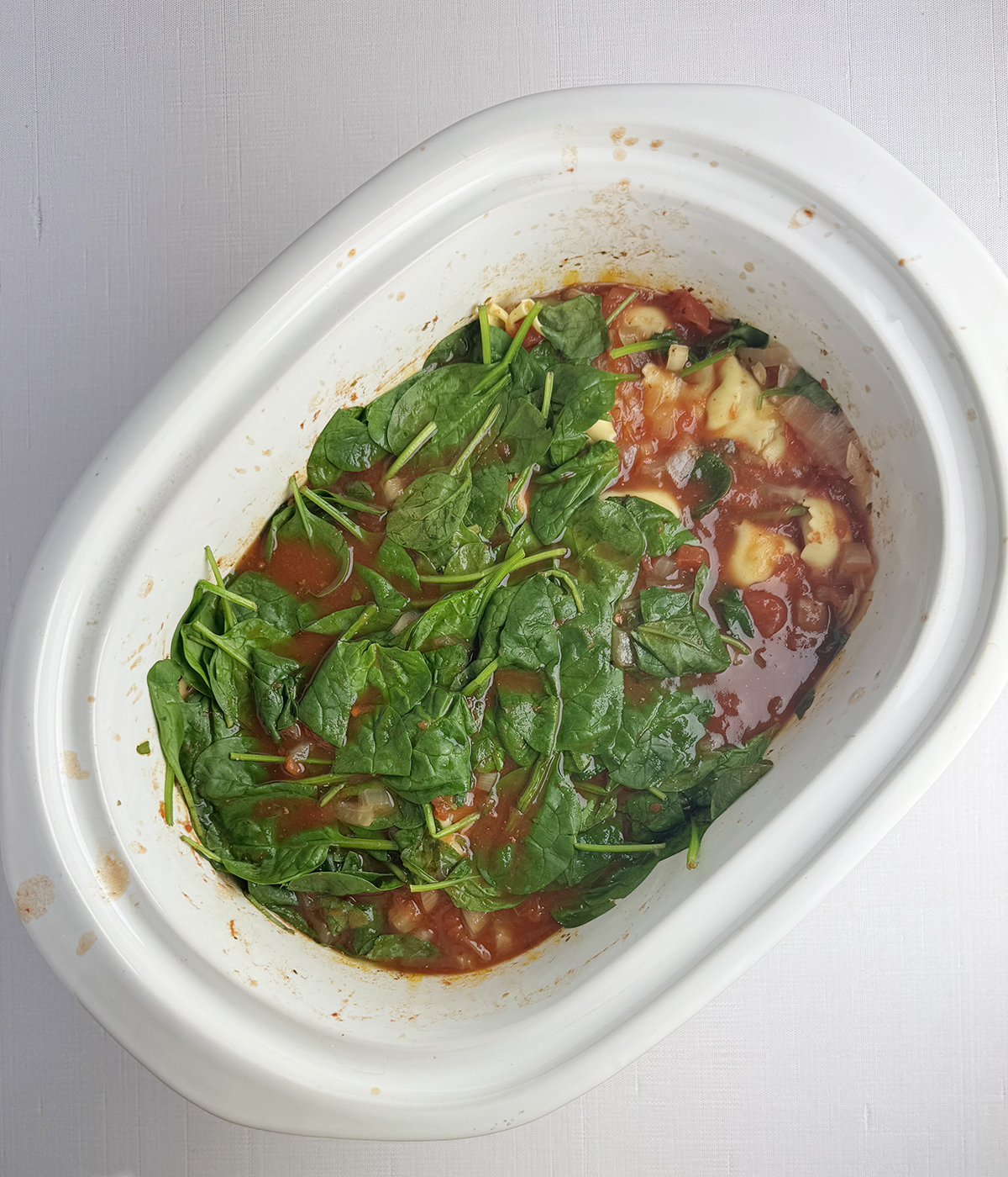 Spinach and tortellini in a slow cooker.