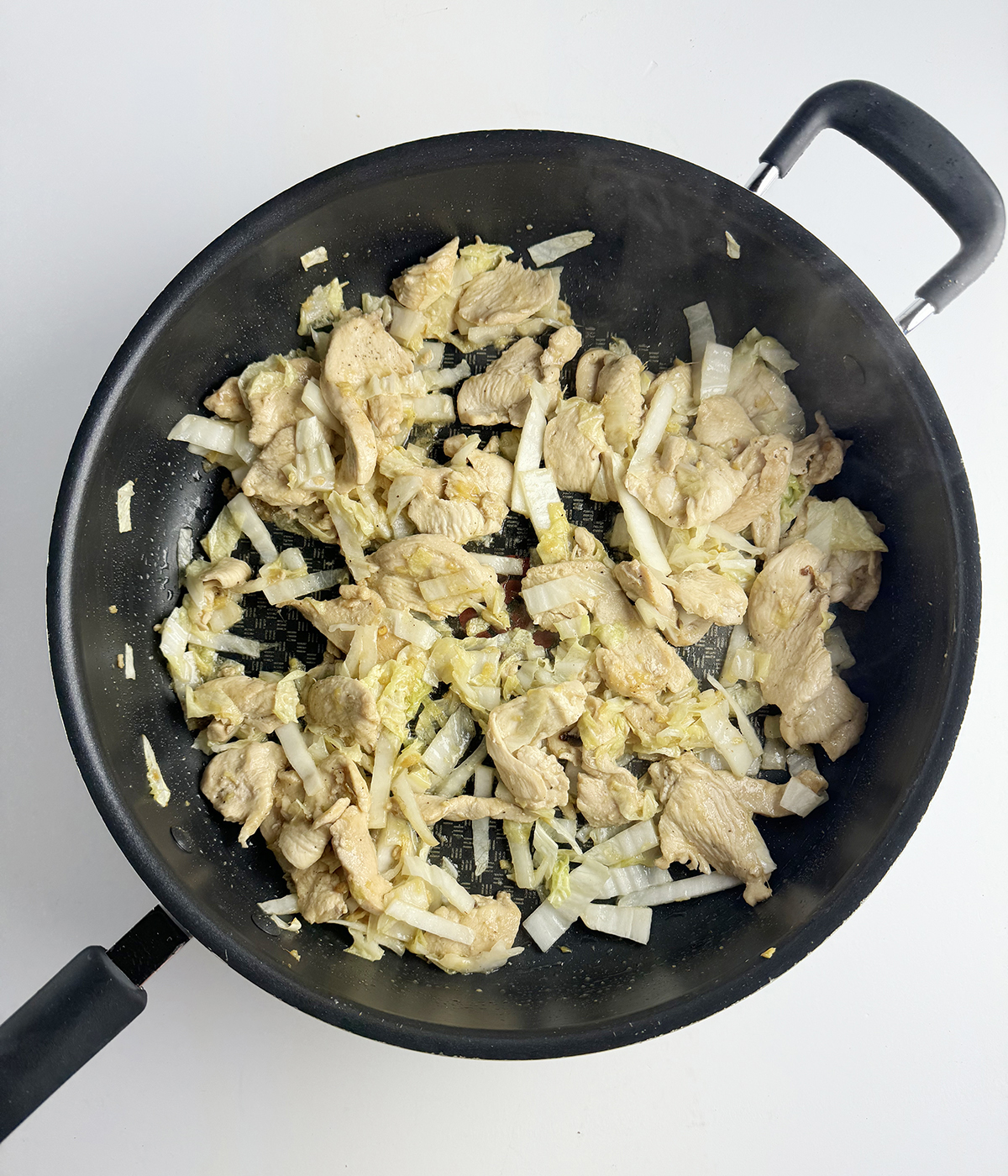Chicken and cabbage in a skillet.