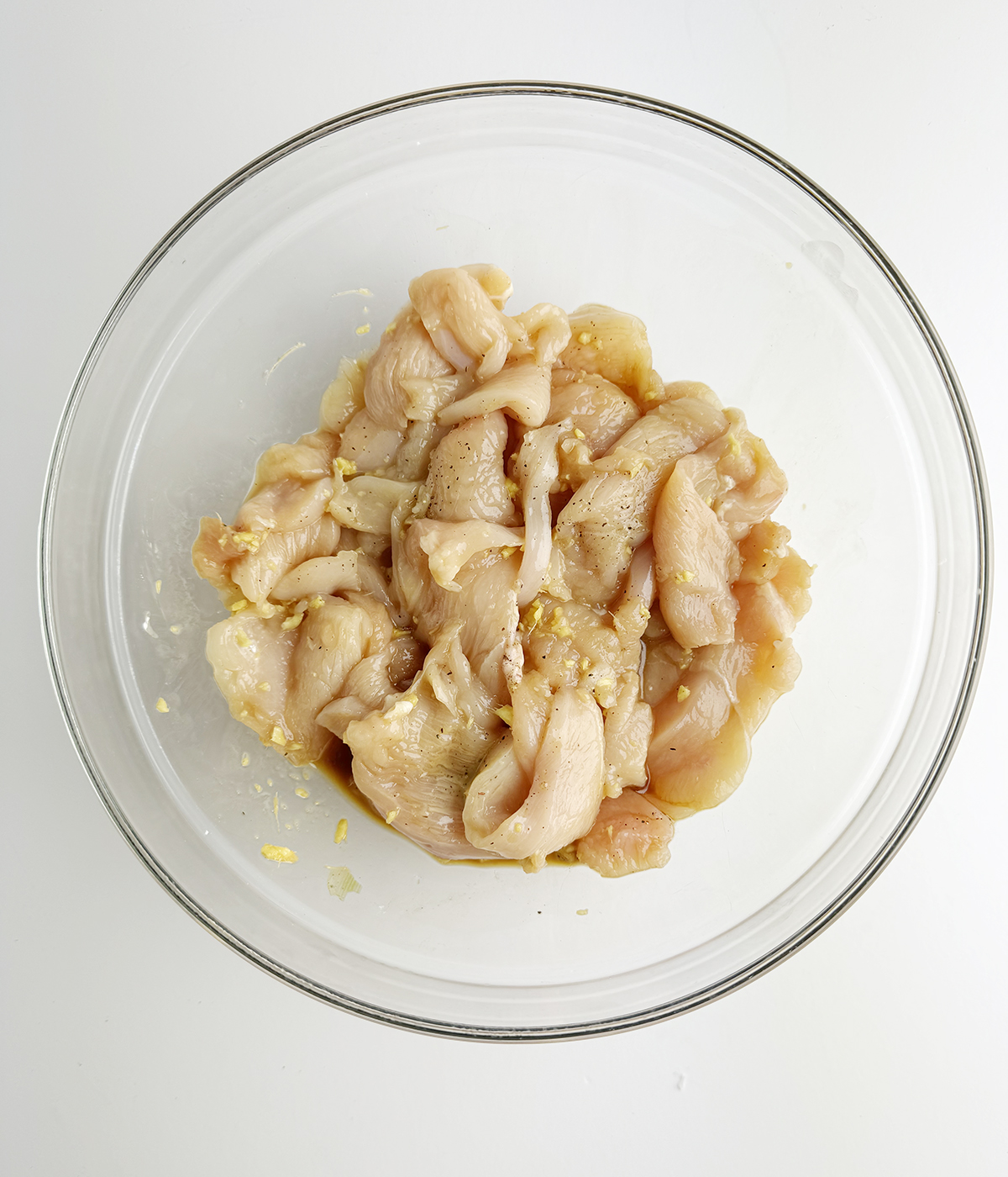 Chicken marinating in a bowl.