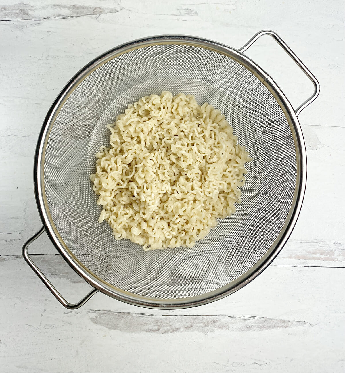 Ramen draining in a strainer.