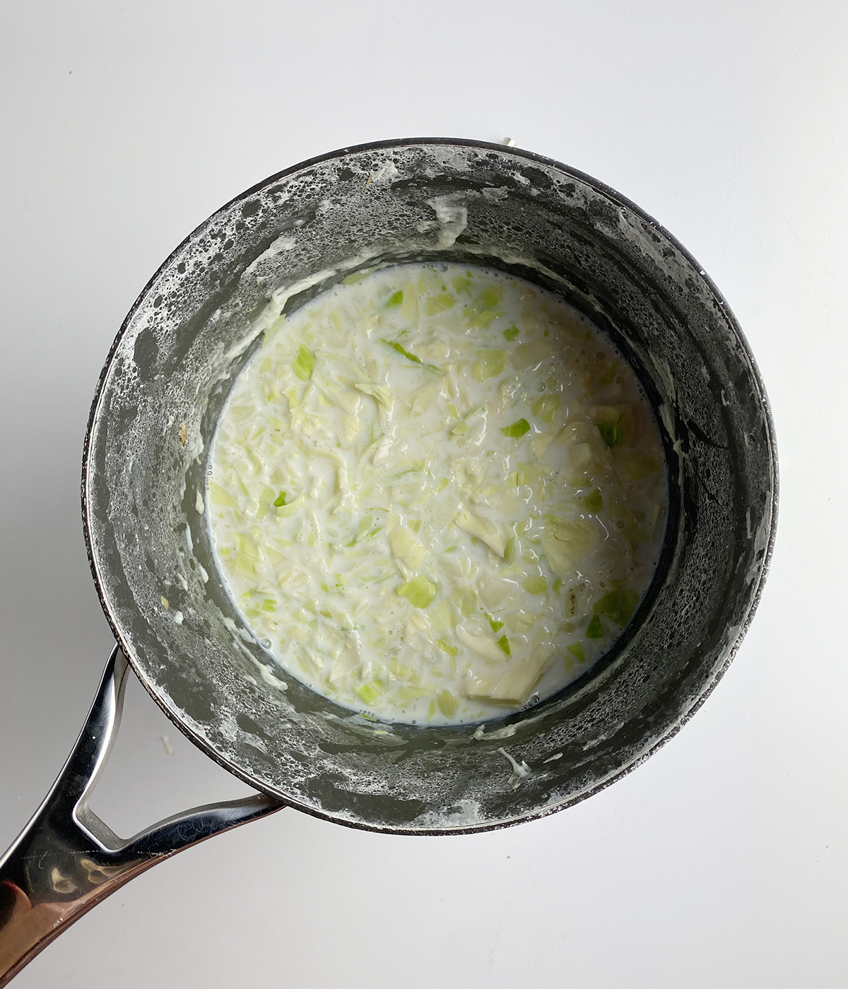 Chopped cabbage cooked in milk in a pot.