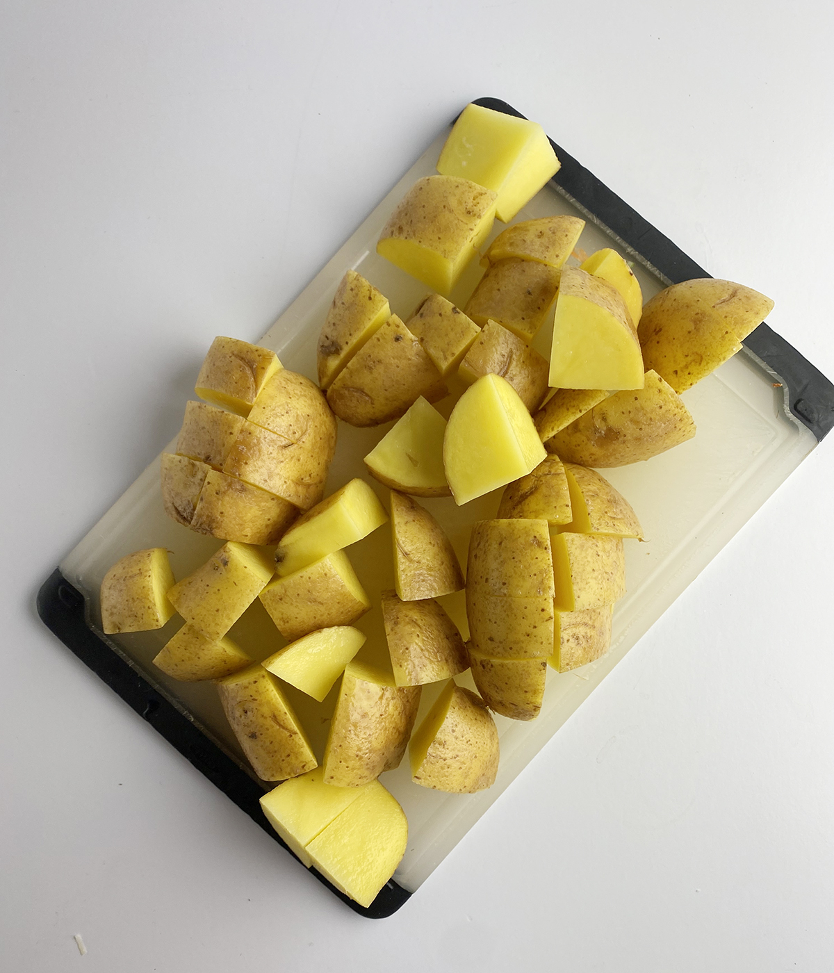 Evenly chopped potatoes on a cutting board.