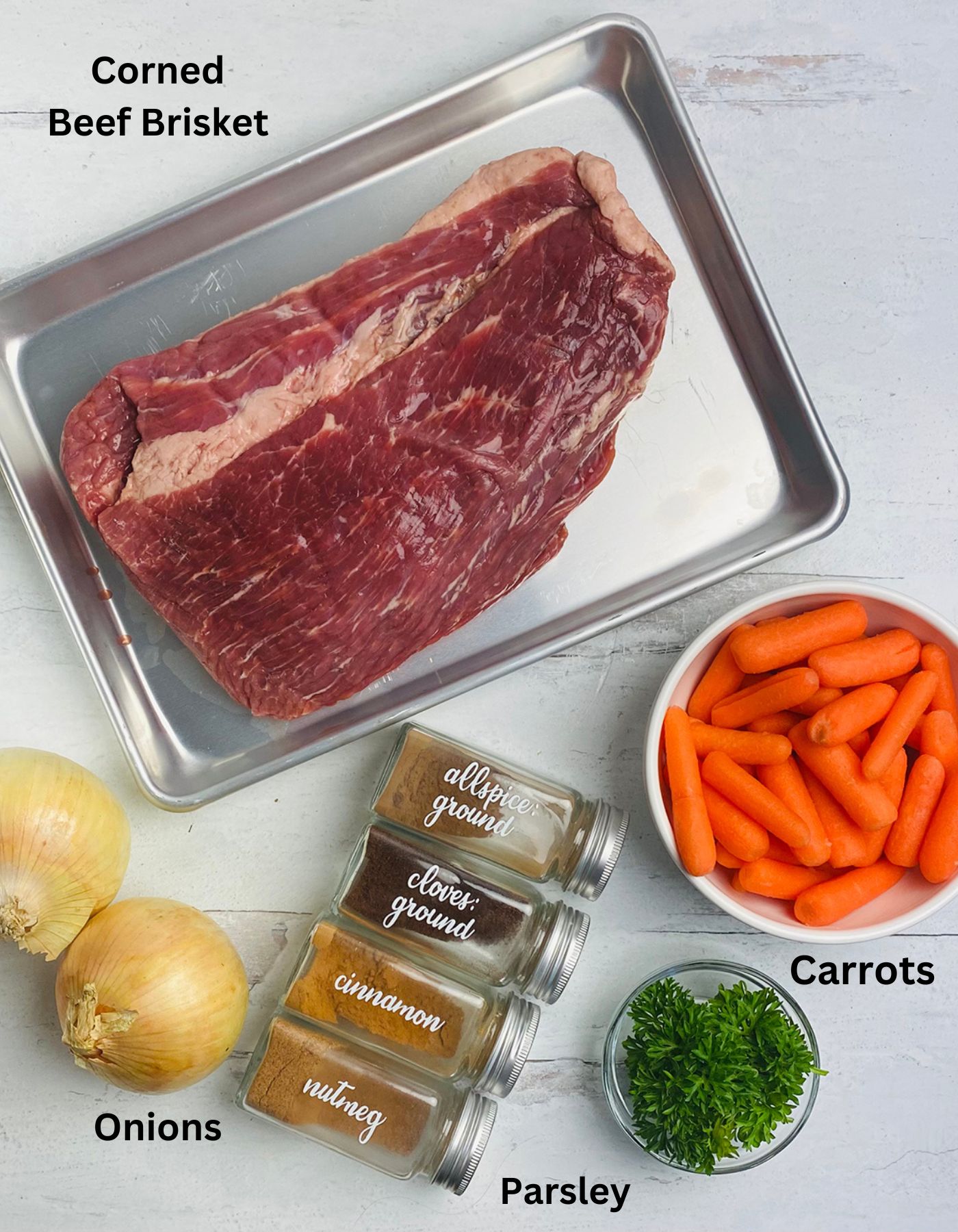 Ingredients needed to make Irish Corned Beef on a marble counter.