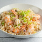 Coconut shrimp ramen in a bowl on a wooden board.