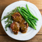 Pork Medallions with Buttered Mustard Sauce on a plate with green beans.