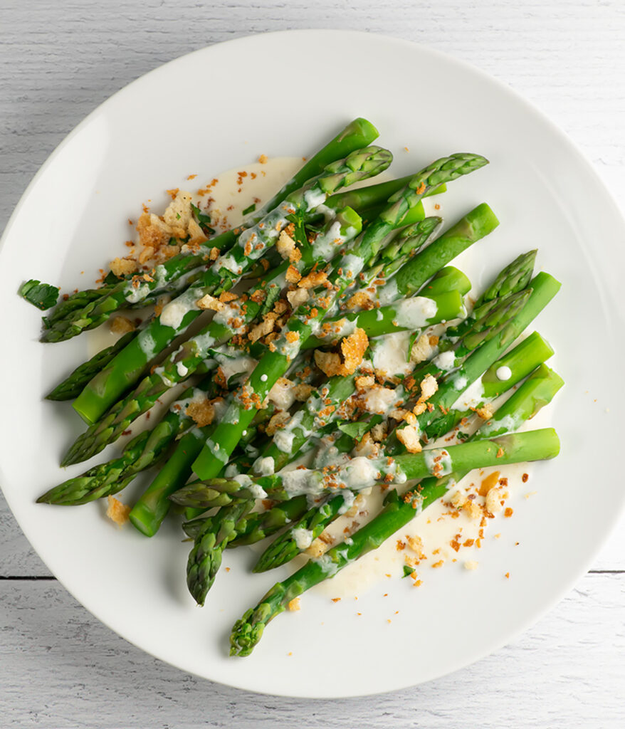 Asparagus with parmesan breadcrumbs on a plate.