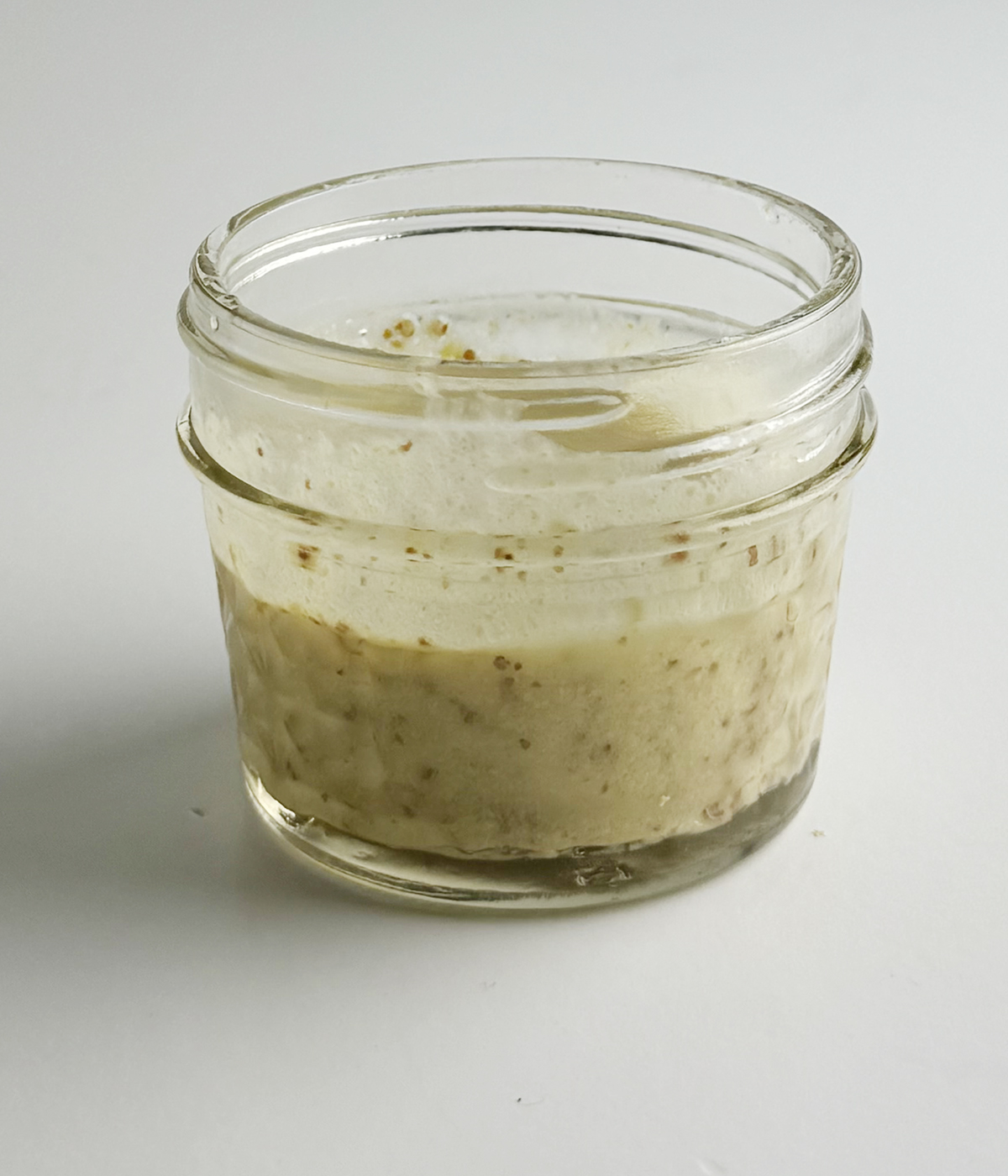 Homemade mustard dressing in a mason jar.