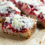 Raspberry coconut bars on parchment paper.