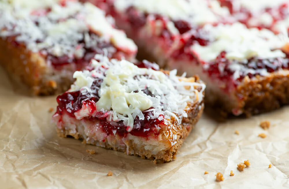 Raspberry coconut bars on parchment paper.