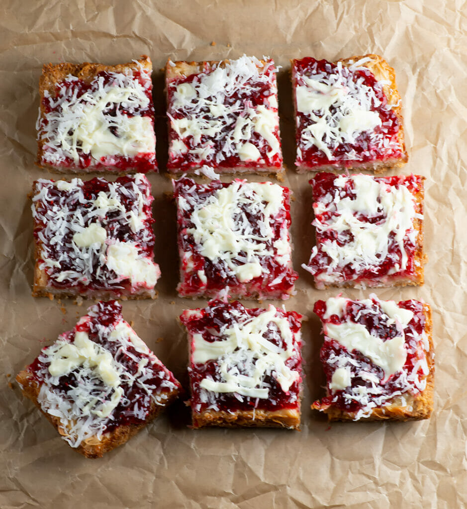 Raspberry coconut bars on parchment paper.