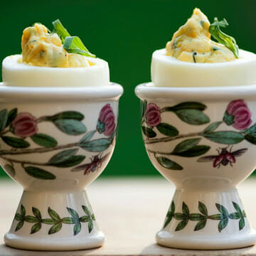 Tarragon deviled eggs in egg cups.