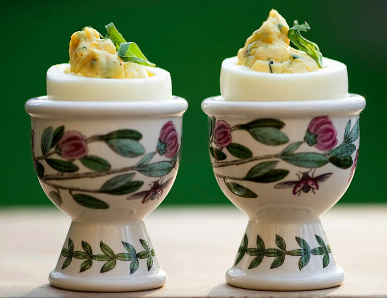 Tarragon deviled eggs in egg cups.